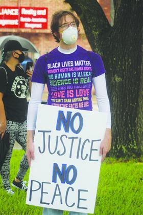 Protesters listen to speeches Thursday on the Putnam County Courthouse lawn.