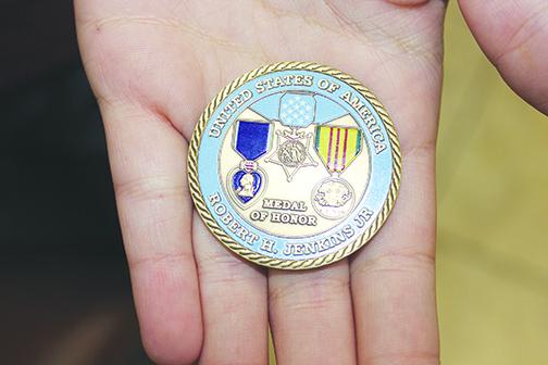 Loztris Vazquez holds a challenge coin, one of the prizes she received for winning the 3rd Battalion Association award.