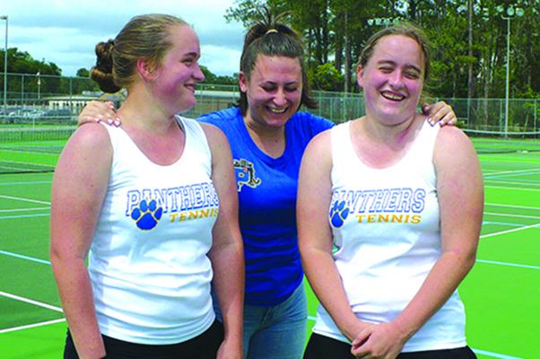 Grace Roebuck, right, laughs at something Palatka High School girls tennis teammate Emma Coyle, center, says, as Grace’s twin sister, Ruth, smiles in the moment earlier in the month. (MARK BLUMENTHAL / Palatka Daily News)