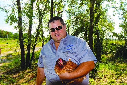 Putnam County Solid Waste Director Jay Tilton with one of the chickens used to help the county monitor viruses caused by mosquitoes.