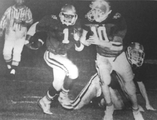 With quarterback Michael Bowman (10) leading the way, Interlachen High School running back Eugene McDonald darts through for yardage in a win during the 1990 season against Dixie County. (Daily News file photo)