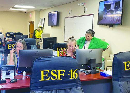 Mary Garcia, right, administrator for the Florida Department of Health in Putnam County, looks on as a staff member takes a call inside the Emergency Operations Center in April before masks were required. 