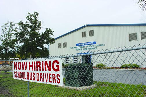 A sign showing the need to hire bus drivers is posted outside the Putnam County School District Vehicle Maintenance building.