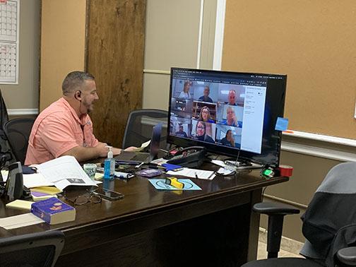 Interlachen High School Principal Bryan Helms talks with staff on a Zoom call Friday in a conference room.