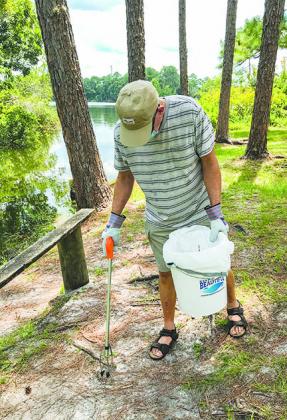 Jim Daniel helps clean Boll Green Boat Ramp in Interlachen earlier this year to make the county a little cleaner during the coronavirus pandemic.