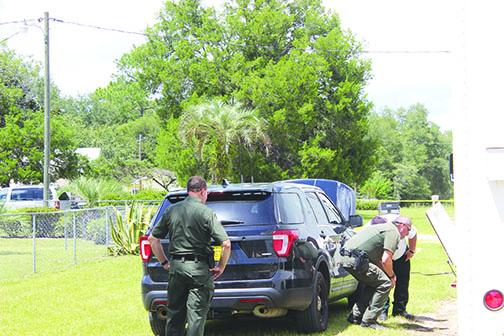 Putnam County Sheriff’s Office deputies set up the mobile command unit Wednesday at a Melrose neighborhood, where two teenagers were found dead.