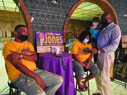 Willie Jones, right, is joined by supporters as he checks election results Tuesday. Jones had 733 votes, just ahead of David Parsons’ 653 total. The two will meet in the Nov. 3 election.