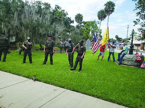 Law enforcement officers watch during Saturday's counterprotest at the Putnam County Courthouse.