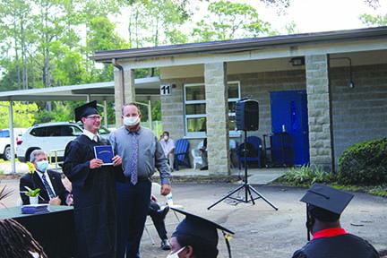 E.H. Miller graduate Judson Rollson shows off his diploma Thursday.