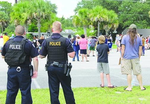 Police officers look on during Saturday's protest at the Putnam County Government Complex.