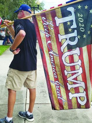 A man holds a flag supporting President Trump at Saturday's counterprotest at the Putnam County Courthouse.