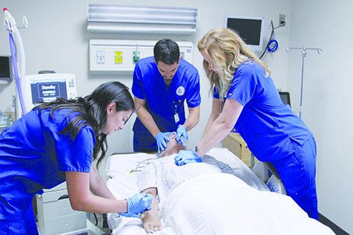 St. Johns River State College respiratory care students Lacy Smith, Robert Kerr and Amber Walters work on resuscitating the program’s computerized mannequin during their lab in 2019.