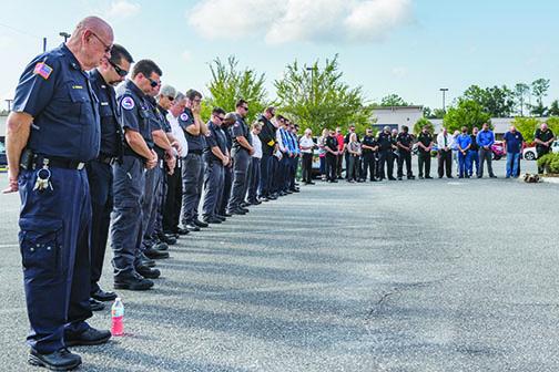 Uniformed personnel bow their heads in prayer to begin the 9/11 remembrance ceremony last year.