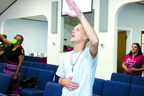 Scott Rea and other participants at the prayer service lift their hands in praise.