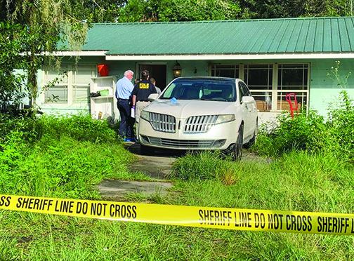 Law enforcement officials investigate the scene of a fatal shooting at 115 Bangor Ave. in East Palatka on Monday morning.