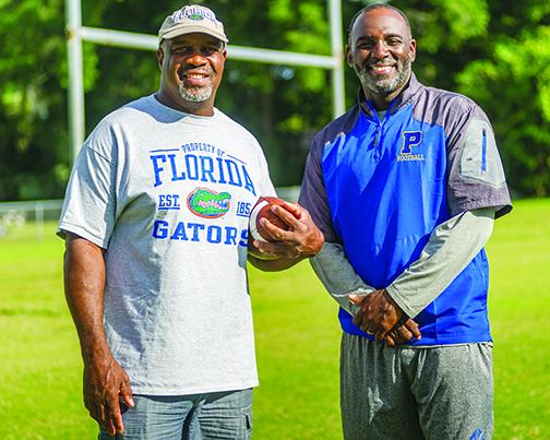 John L. Williams with Palatka High School head coach Willie Fells prior to a spring football practice in 2019.