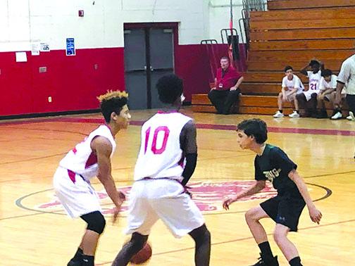 A basketball player from the Putnam Academy of Arts & Sciences, right, guards two C.H. Price Middle School players during a game last season. District officials have postponed middle school sports until spring.