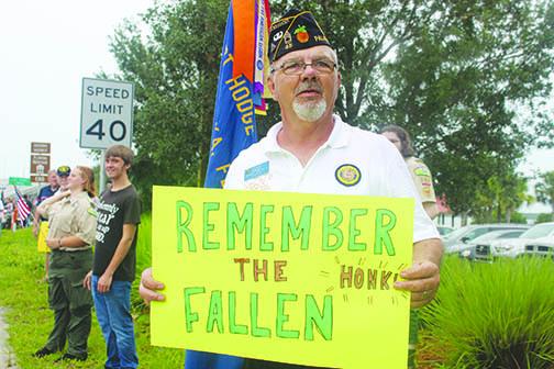 Ken Moore, commander of American Legion Bert Hodge Post 45, holds a sign marking Memorial Day in May. Moore said veterans who need to talk to someone can contact him. 