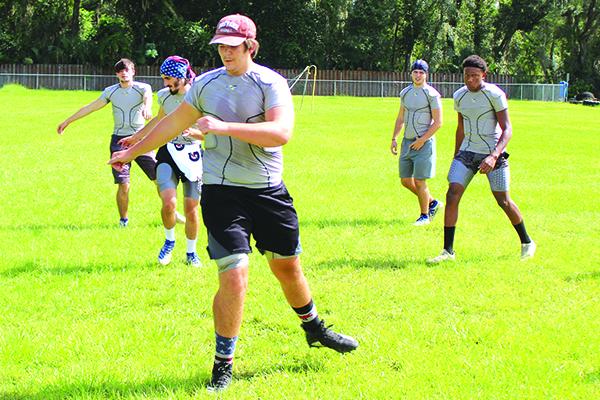 Aiden Sullivan leads his Peniel Baptist Academy six-man football team through exercise drills during practice last month. The Warriors host Gainesville Christian tonight at Theobold Sports Complex. (MARK BLUMENTHAL / Palatka Daily News)
