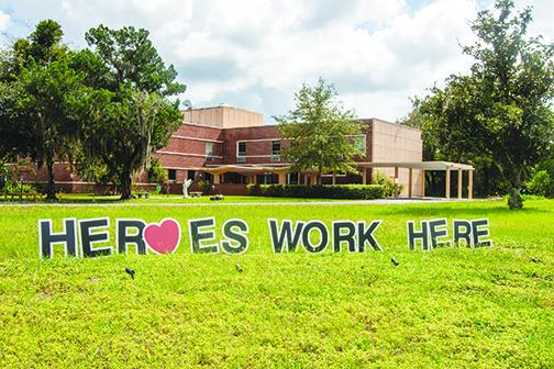 “Heroes Work Here” beams brightly at Windsor Care and Rehab in Palatka on Thursday afternoon.