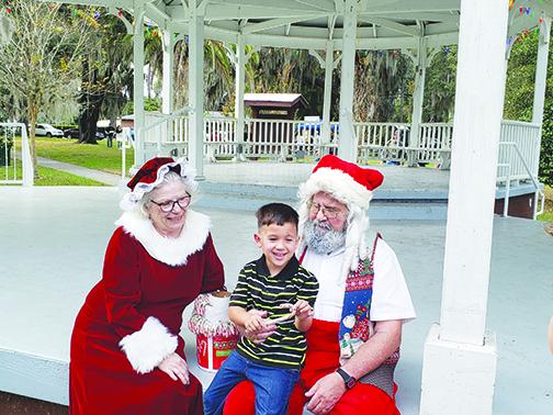 Santa and Mrs. Claus greet a young boy during Christmas in the Park last year in Crescent City.