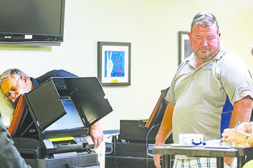 Elections Supervisor Charles Overturf III and County Commissioner Jeff Rawls check the ballot processing machines Friday to make sure they are ready for election season. 