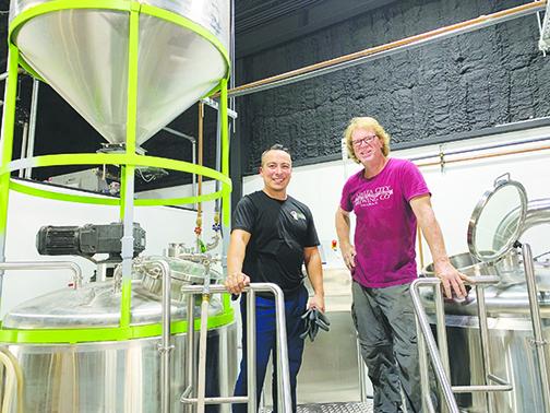 Azalea Brewing Co. head brewer Eli Miranda and facilities manager Rod Wies stand near brewing equipment Tuesday.