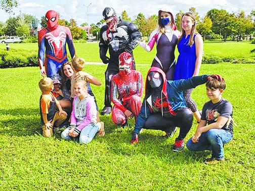 Johnathan Garcia and other volunteers dress up Saturday and take pictures with local children ahead of Halloween.