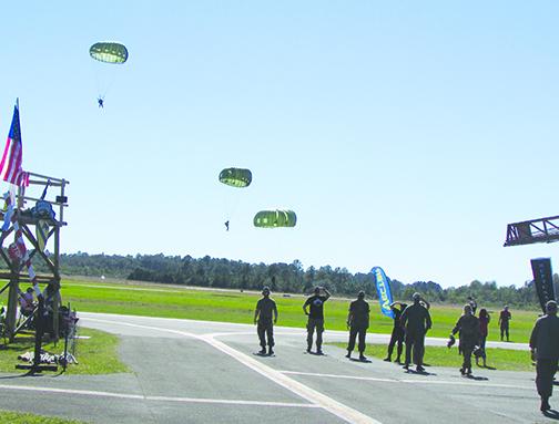 Paratroopers land at Kay Larkin Field on Friday afternoon after jumping from a Huey helicopter as part of Operation Black Cat IV honoring Vietnam veterans. 