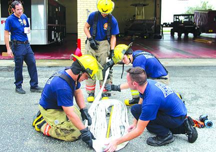 New recruits at the Palatka Fire Department prepare a metro load to put on the fire truck. Kneeling, from left, are rookies Marcus Wilson and Cane Willsey and firefighter/EMT Mike Vogel. Standing are engineer Stephen Barker, left, and rookie Jacob O’Connor.