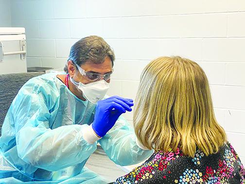 Florida Department of Health in Putnam County employee Bruce Florence swabs a local resident for COVID-19 on Monday at the Palatka testing center. 