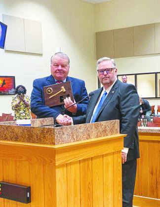 Turner receives a plaque from County Administrator Terry Suggs during the board meeting Tuesday.