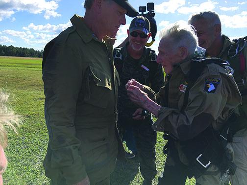 Skydive Palatka’s Art Shaffer, right, looks on as World War II veteran James “Pee Wee” Martin pins jump wings on the coat of his son, Roger Martin, Oct. 31.