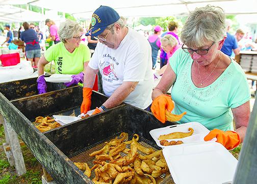 Catfish Festival vendors fry up and plate fish during the 2019 event.