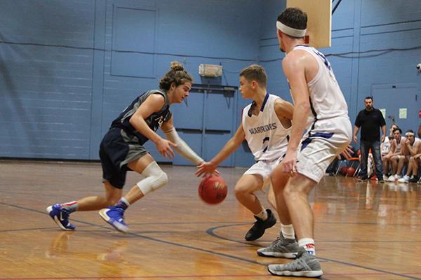 Bunnell First Baptist Christian point guard Jeremiah Smith dribbles late in Thursday’s game against Peniel Baptist Academy against defender Trae Jenkins as teammate Jeremiah Sweet backs up behind Jenkins. (MARK BLUMENTHAL / Palatka Daily News)