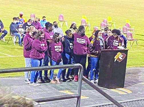 Jordan Williams is joined by members of the Crescent City High School girls weightlifting team as she speaks at Thursday night’s vigil honoring their coach, Stacy Cook, and senior Leslie Vazquez.