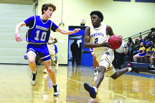 Palatka High School’s Vanari Johnson (right) takes the ball to the basket against Gainesville High’s Cal Evans during Tuesday night’s game. (MARK BLUMENTHAL / Palatka Daily News)
