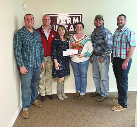 Palatka High School agricultural sciences teacher Alexis Tilton, third from right, hold checks she received from the Putnam-St. Johns Farm Bureau board of directors and the Florida Farm Bureau for her classroom.