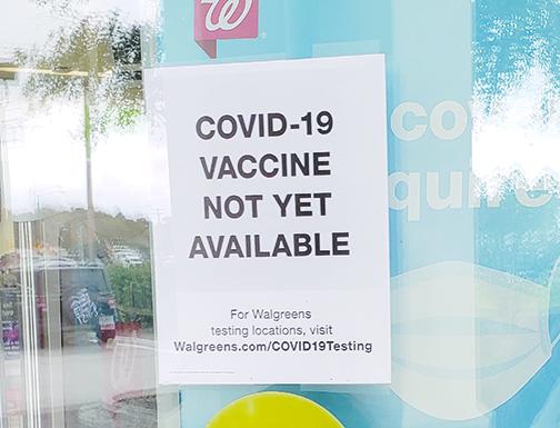 Signs on the door of Walgreens in Palatka show COVID-19 vaccines are not yet available to the public. 