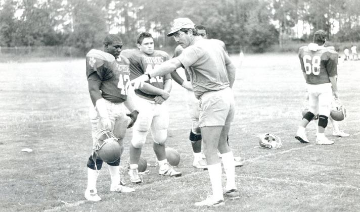Palatka High line coach Tony Alred makes his point to linemen Darrell Polite, left, David Hudson and Joel Walker (behind) during a 1989 practice. Alred passed away Friday at the age of 75. (Daily News file photo)
