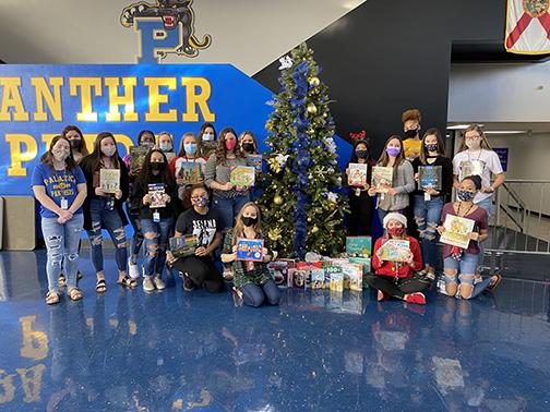 Interact Club members at Palatka High School with books they gathered for students at James A. Long Elementary School. The donation helped the school provide each of its students with a book and a blanket for the holidays.