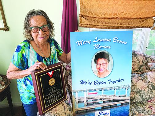 Palatka City Commissioner Mary Lawson Brown holds her Florida League of Cities Lifetime Achievement Award as well as a cutout of her and the city’s marina, which was renamed the Mary Lawson Brown Marina.