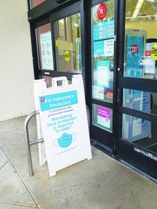 A sign outside Walgreen in Palatka informs customers they must wear a mask while in the store to prevent the spread of coronavirus. 