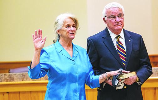 Putnam County Tax Collector Linda Myers places her hand on the bible her husband, former Palatka Mayor Vernon Myers, holds as she is sworn in for another term.