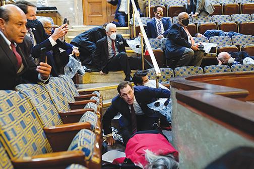 People shelter in the House gallery as protesters try to break into the House Chamber at the U.S. Capitol on Wednesday in Washington.