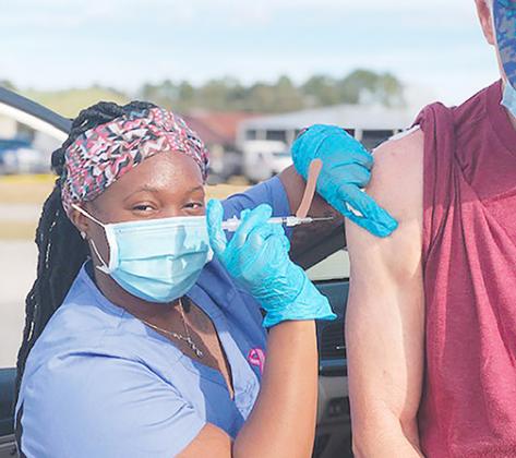 An employee with the state Department of Health in Putnam County gives a dose of the Moderna COVID vaccine to a Putnam man.