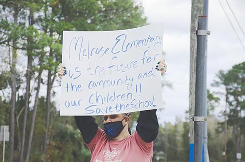 A woman advocates against closing Melrose Elementary School during a protest Friday.