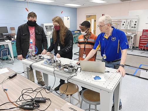 Palatka High School teacher Bob Knutsen instructs advanced manufacturing program students, from left, Micah Hall, Anthony Ero and Derrick Davis.