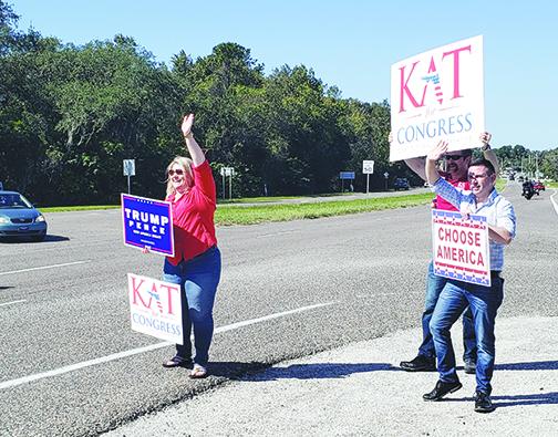 Kat Cammack waves to motorists before the 2020 general election.
