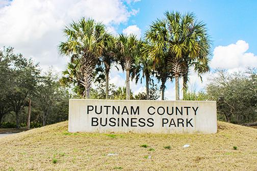 A mask, an empty beer bottle and other debris lie in front of the Putnam County Business Park entrance in Palatka.